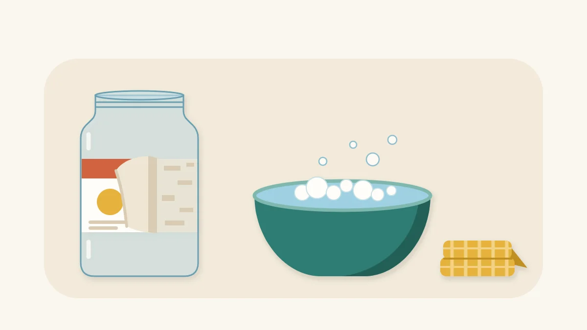 A glass jar with its paper label half peeled away beside a bowl of soapy water and a cloth